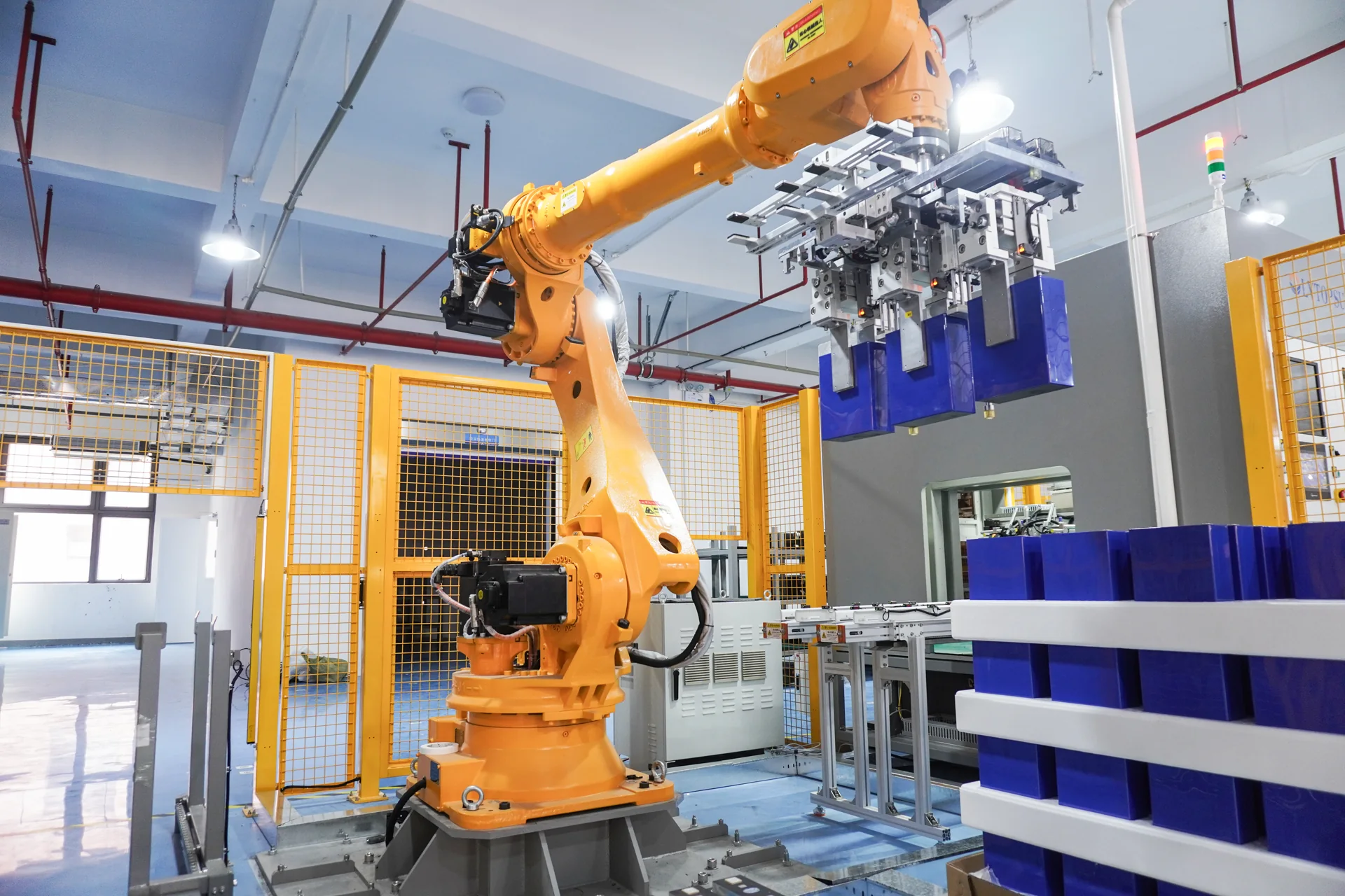 Robotic arm transferring battery cells
